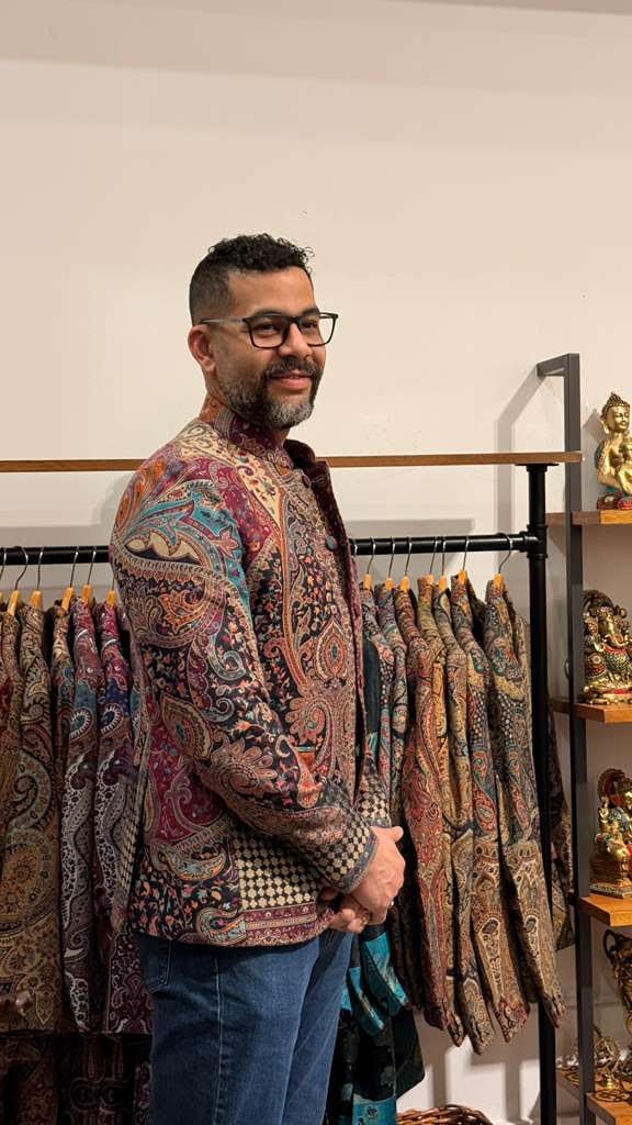 Customer trying on a paisley patterned jacket in the store